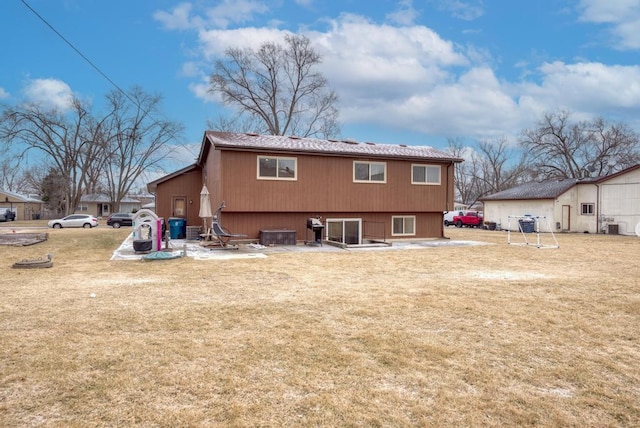 rear view of house featuring a patio and a lawn