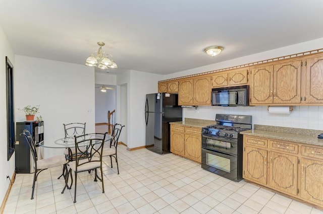 kitchen featuring pendant lighting, a notable chandelier, decorative backsplash, and black appliances