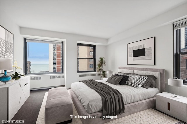 carpeted bedroom with a water view and radiator heating unit