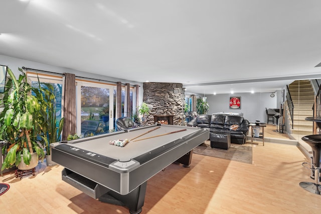 game room featuring a fireplace, pool table, and light hardwood / wood-style flooring