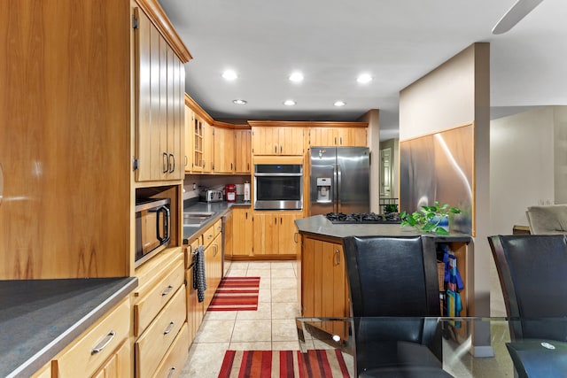 kitchen featuring light tile patterned flooring and stainless steel appliances