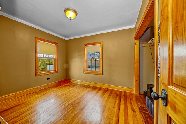 empty room featuring hardwood / wood-style flooring and crown molding