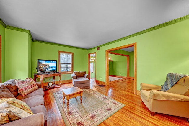 living room with light hardwood / wood-style floors and crown molding