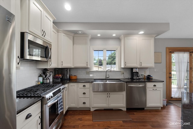 kitchen with dark hardwood / wood-style floors, a healthy amount of sunlight, sink, and stainless steel appliances