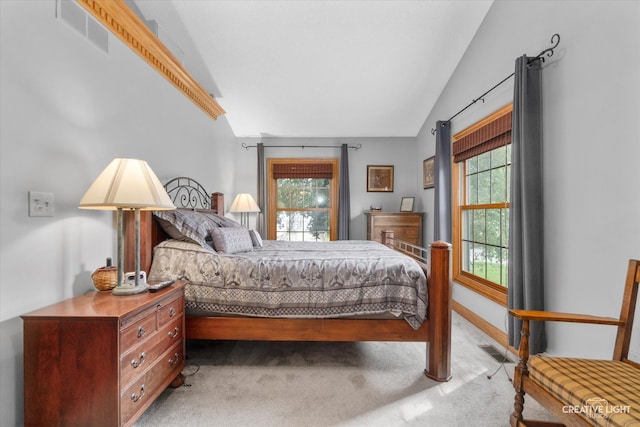 carpeted bedroom featuring vaulted ceiling and multiple windows