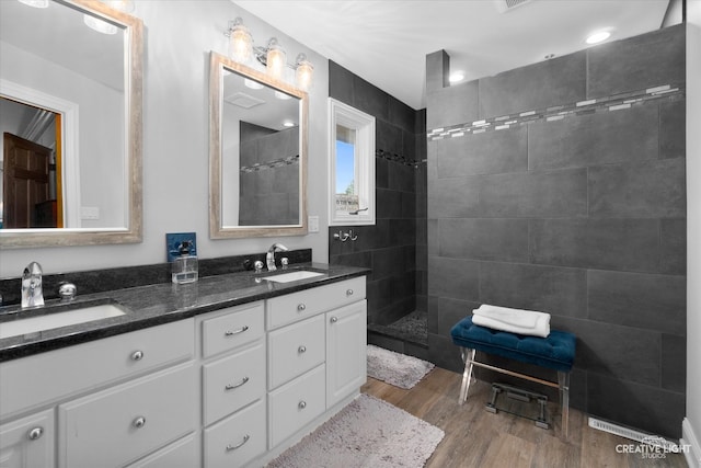 bathroom featuring a tile shower, hardwood / wood-style floors, and vanity