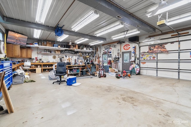 garage featuring a workshop area, a garage door opener, and ceiling fan