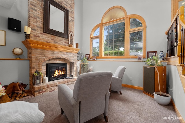 carpeted living room featuring a high ceiling and a brick fireplace