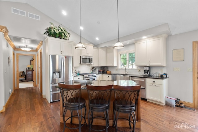 kitchen with white cabinets, decorative light fixtures, dark hardwood / wood-style flooring, and appliances with stainless steel finishes