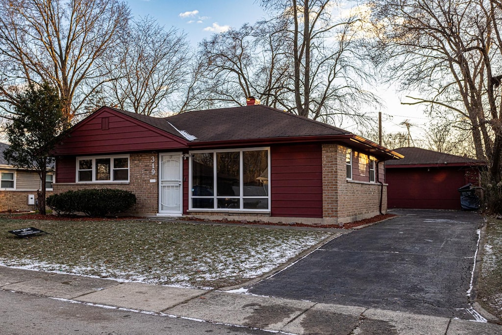 single story home with a garage and a front lawn