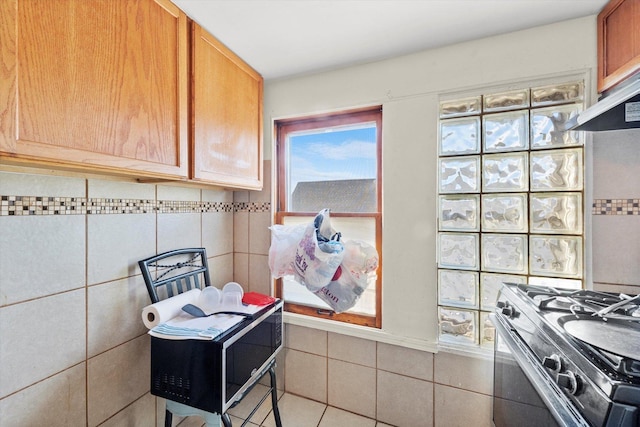 2425 W 46th Pl, Chicago, IL 60632 - kitchen with black gas range oven, tile walls, and under cabinet range hood