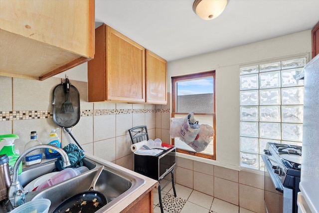 2425 W 46th Pl, Chicago, IL 60632 - kitchen featuring range with gas stovetop, tile walls, a sink, and light tile patterned floors