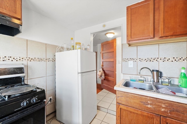 2425 W 46th Pl, Chicago, IL 60632 - kitchen featuring freestanding refrigerator, range with gas cooktop, extractor fan, a sink, and light countertops
