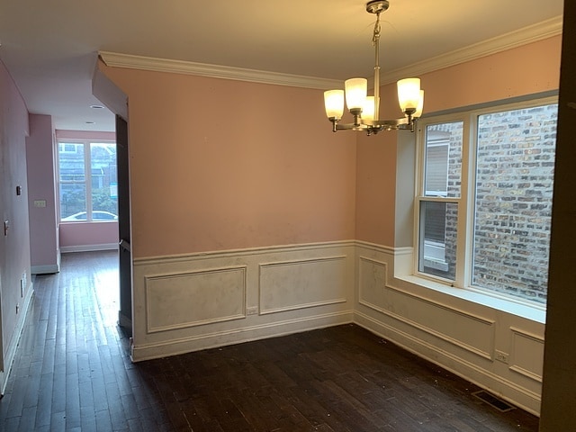 empty room featuring ornamental molding and dark hardwood / wood-style flooring