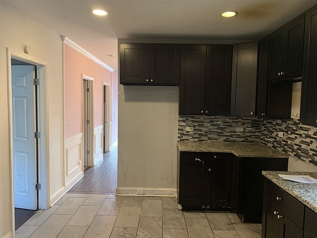 kitchen featuring light stone counters and tasteful backsplash