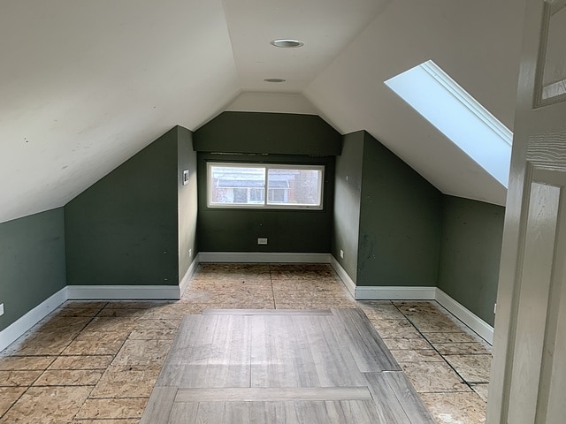 bonus room featuring vaulted ceiling with skylight