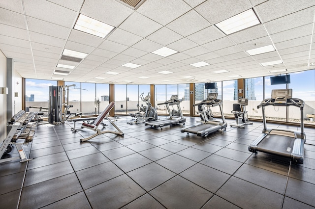 exercise room featuring a drop ceiling and floor to ceiling windows