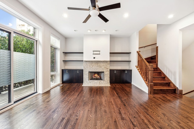 unfurnished living room with dark hardwood / wood-style flooring and ceiling fan