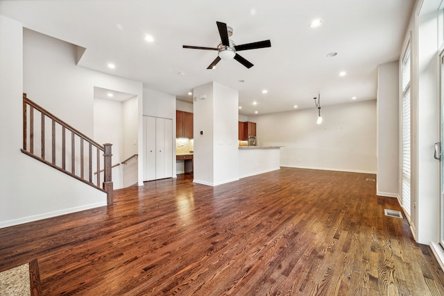 unfurnished living room with dark hardwood / wood-style flooring and ceiling fan