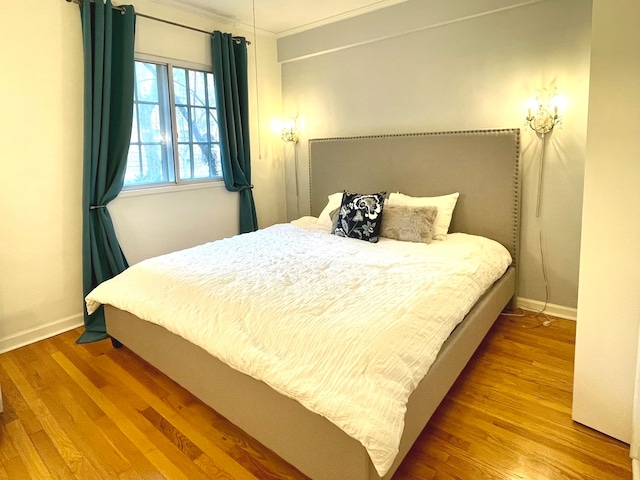 bedroom with crown molding and hardwood / wood-style floors