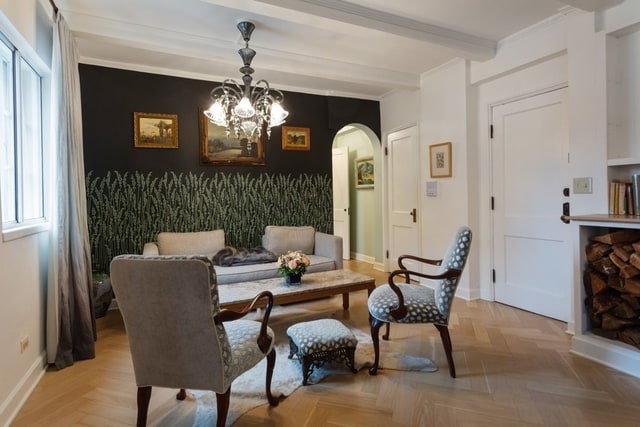 living area featuring a notable chandelier, ornamental molding, and light parquet flooring