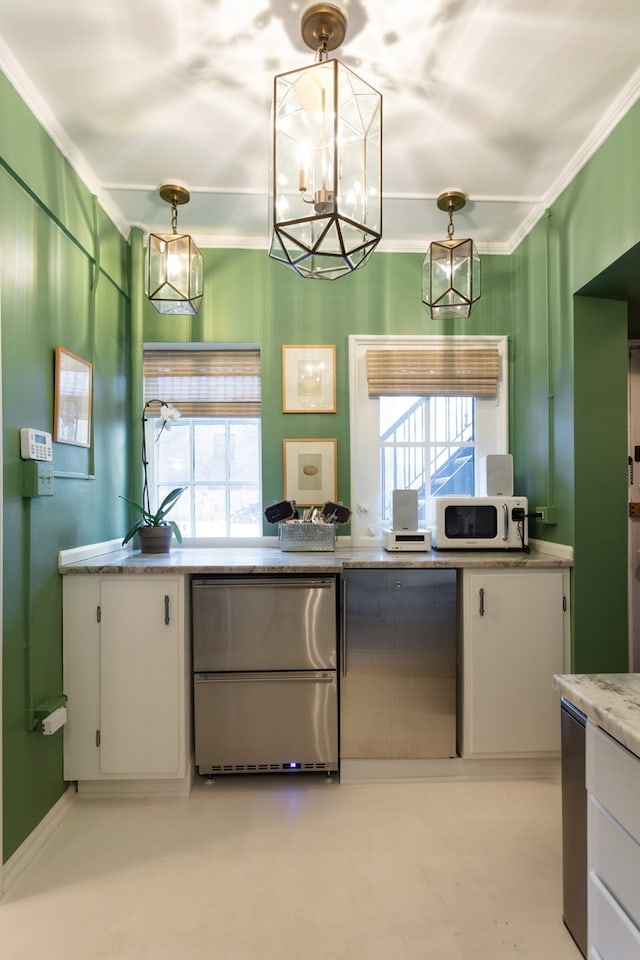 kitchen featuring decorative light fixtures, white cabinetry, and stainless steel refrigerator