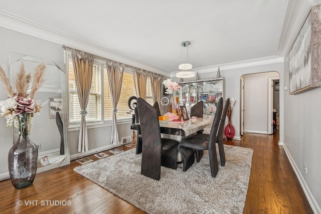 dining area featuring crown molding and dark wood-type flooring