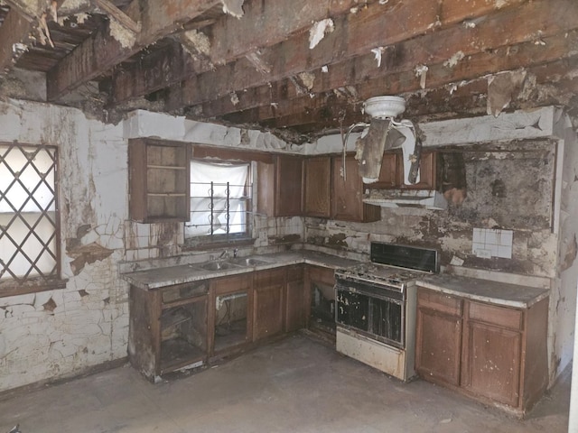 kitchen with stove, sink, ventilation hood, and concrete floors