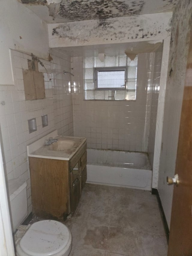 bathroom with tiled shower / bath combo and vanity