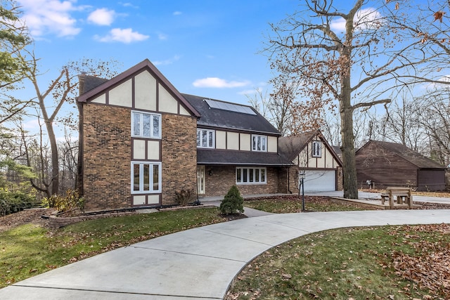 english style home with a garage and a front yard