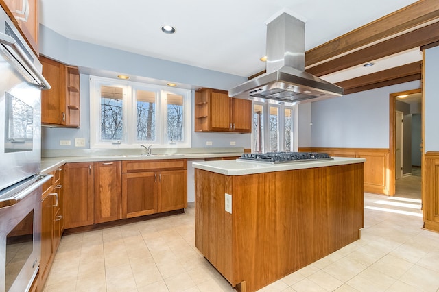 kitchen featuring island exhaust hood, appliances with stainless steel finishes, a center island, and a wealth of natural light