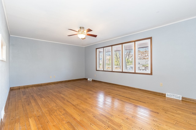 spare room featuring light wood-type flooring, ceiling fan, and crown molding