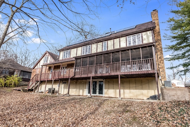 back of house featuring a sunroom and a wooden deck