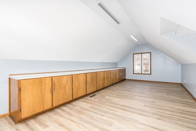 bonus room featuring lofted ceiling and light hardwood / wood-style flooring