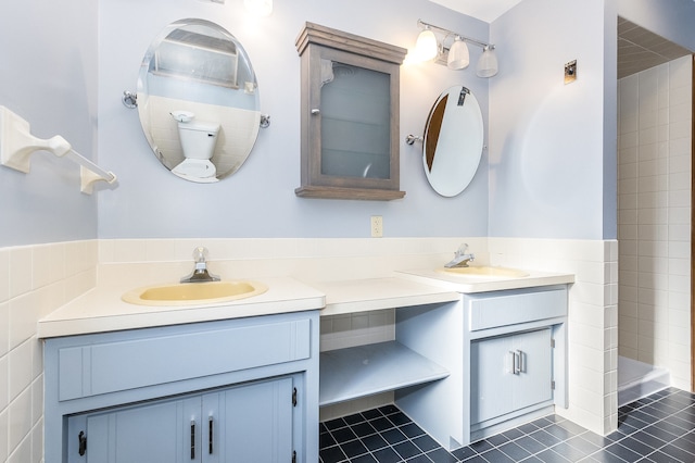 bathroom with vanity, tile patterned floors, and tile walls