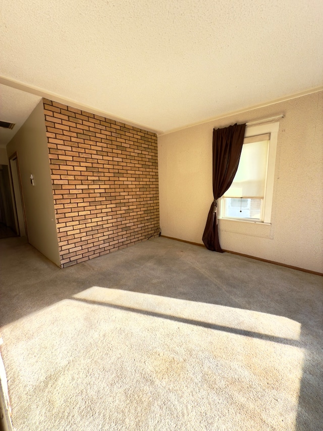 unfurnished living room with carpet, brick wall, and a textured ceiling