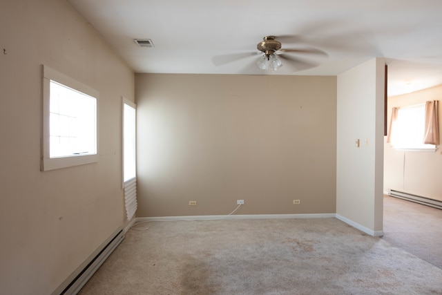 carpeted spare room featuring a baseboard heating unit and ceiling fan