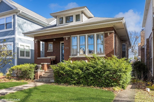 bungalow-style house with brick siding