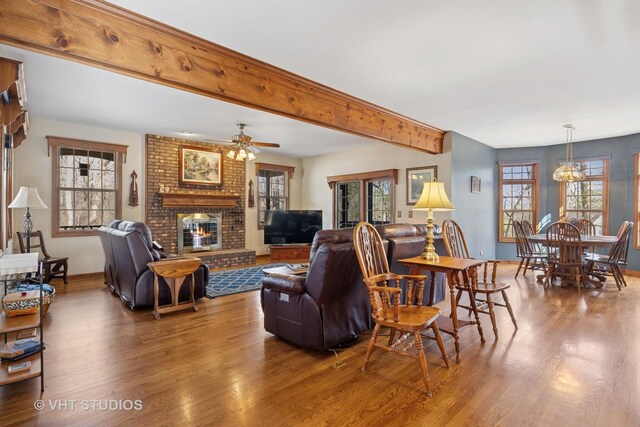 2418 Bennington Ln, Mchenry, IL 60050 - living room featuring wood finished floors, a brick fireplace, a ceiling fan, healthy amount of natural light, and beamed ceiling