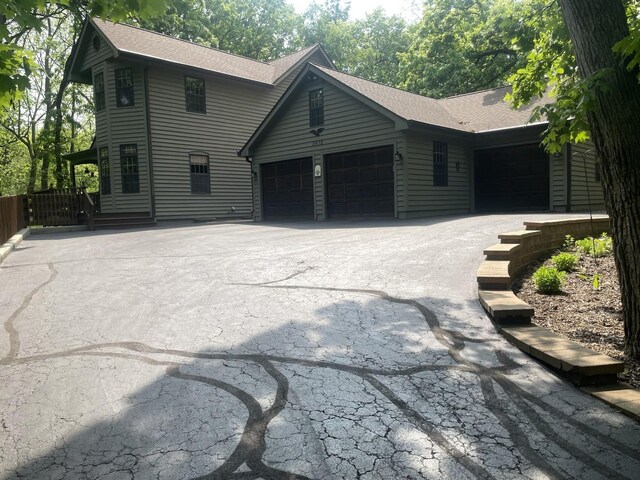 2418 Bennington Ln, Mchenry, IL 60050 - view of front of house featuring a garage, a shingled roof, and driveway