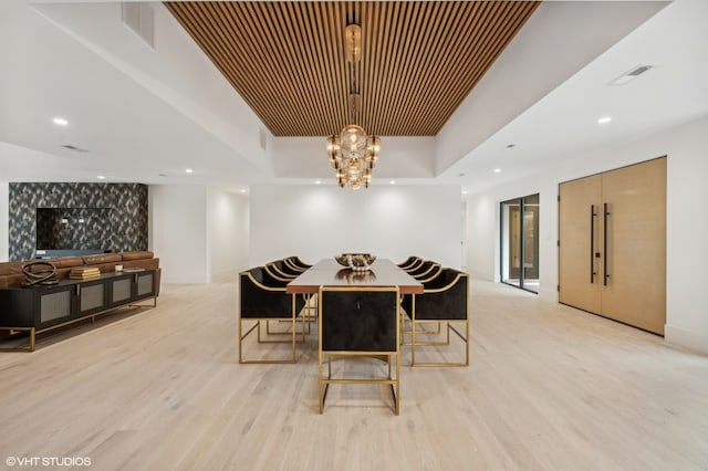 dining room with light hardwood / wood-style floors and an inviting chandelier