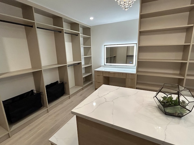 walk in closet featuring a chandelier and wood-type flooring