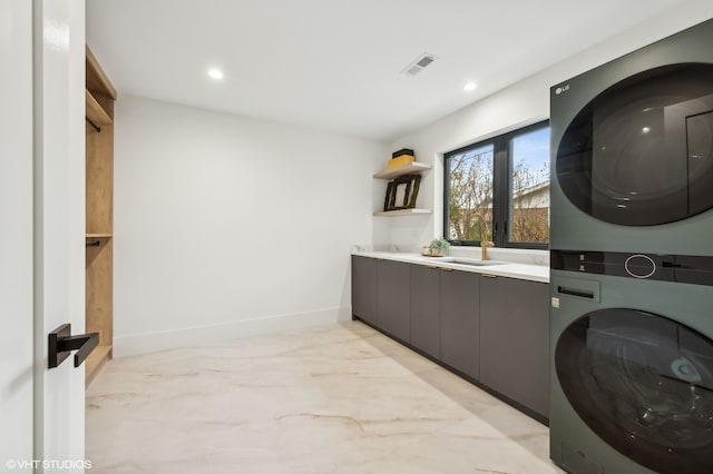 washroom featuring stacked washer / dryer and sink