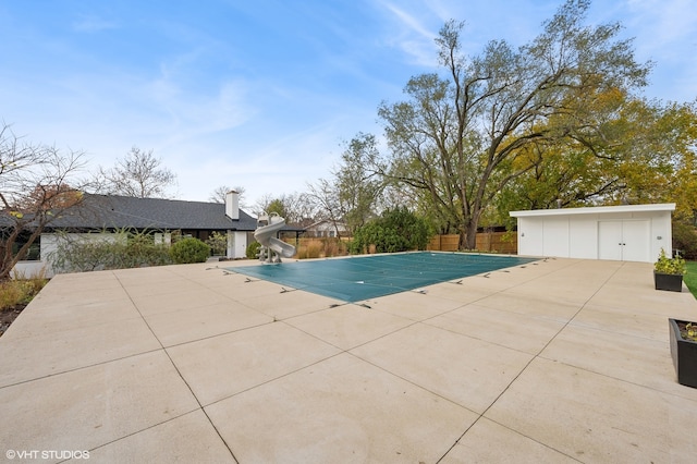 view of swimming pool with a patio area and a water slide