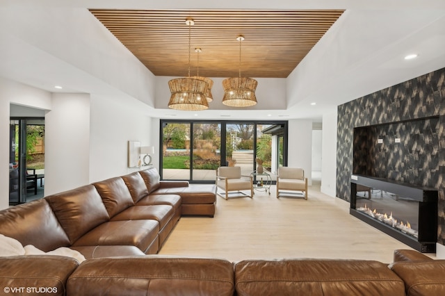 living room with a towering ceiling and light hardwood / wood-style flooring