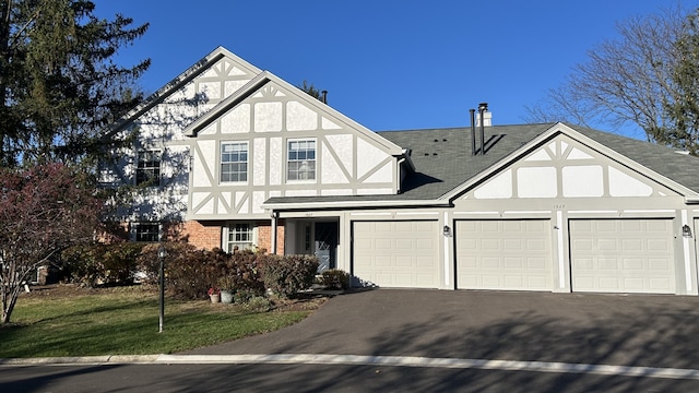 english style home featuring a garage and a front yard