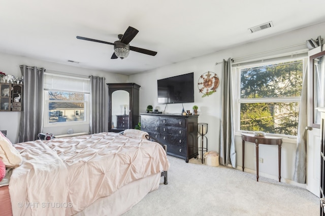 bedroom featuring multiple windows, ceiling fan, and carpet