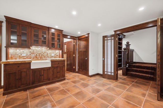 kitchen with light tile patterned floors, tasteful backsplash, and sink