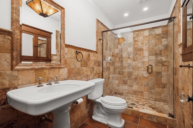 bathroom with tile patterned floors, tile walls, an enclosed shower, and toilet