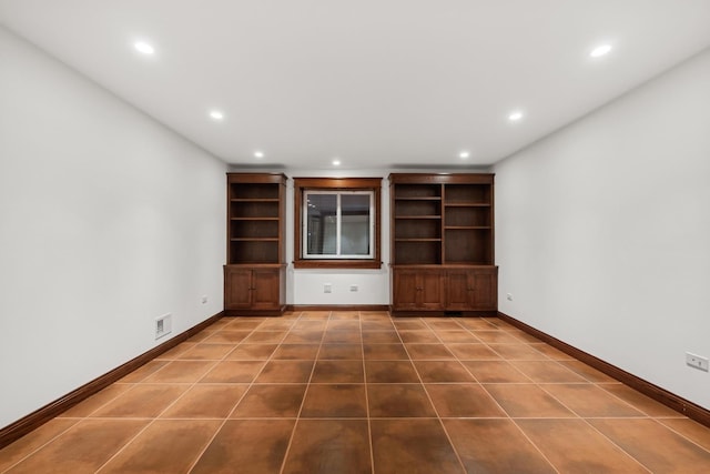 unfurnished living room featuring dark tile patterned floors